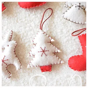 Close-up of handmade felt Christmas ornaments with delicate snowflake embroidery details