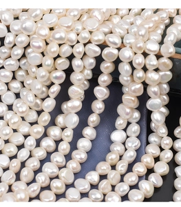 Macro close-up of natural baroque freshwater pearls with high luster on blue silk fabric