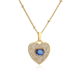 Close-up of gold heart necklace with micro-pave crystals and a central blue stone