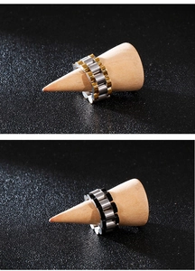 Macro detail of stainless steel watch band style rings in gold and black two-tone finishes