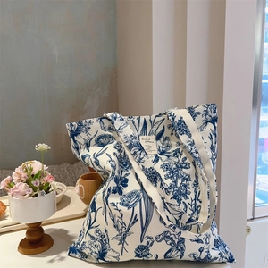 Detail of large canvas tote bag with vintage blue floral patterns and fabric label