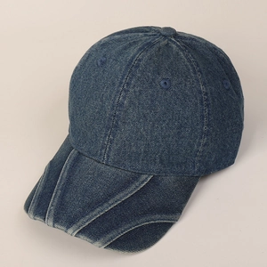 Detailed close-up of distressed navy blue denim cap with layered brim and embroidery holes