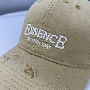 Detail of khaki cotton baseball cap showing vintage distressed holes and 3D embroidery