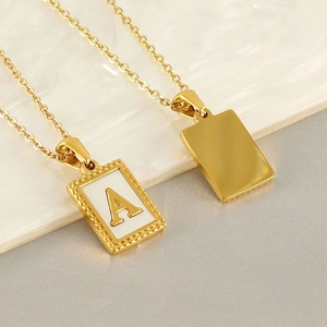 Goldene Edelstahlkette mit geprägtem Buchstaben A Anhänger auf Marmorhintergrund