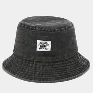 Détail d'un bob en denim délavé gris avec un écusson en tissu vintage Brooklyn New York