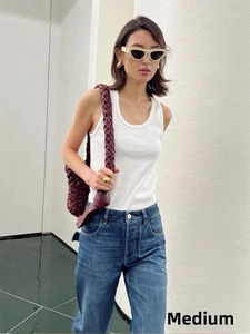 Street style shot of medium burgundy woven leather handbag with knot handle detail