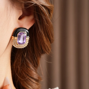 Close-up of vintage square purple enamel and diamond earring worn by a model