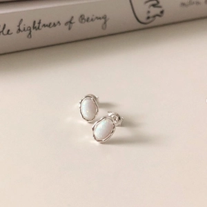 Macro shot of S925 sterling silver opal stud earrings on a clean minimalist background