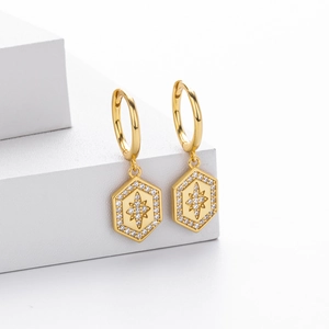 Macro detail of gold-plated starburst hoop earrings with micro-set cubic zirconia
