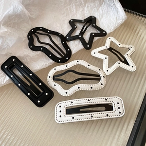 Detail of 6-piece black and white polka dot star hairpins with leather texture and metal clips