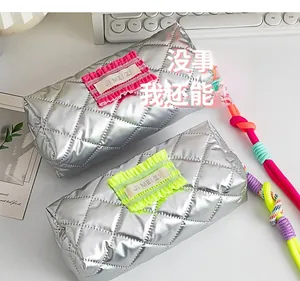 Detail of silver quilted pencil case with contrast neon ruffles and woven rope handle