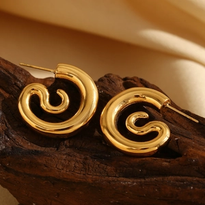 Macro shot of 18K gold plated stainless steel spiral snake earrings on wood