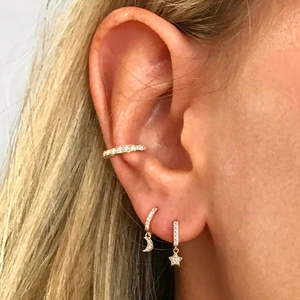 Detail of gold-plated S925 star and moon drop earrings with zircon cuff on ear
