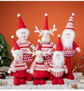 Detailed view of plush Santa, reindeer and snowman dolls in striped Christmas outfits