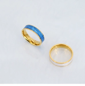 Detail view of blue and white enamel inlay on 18K gold plated stainless steel rings