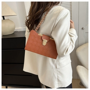 Detail of woven texture faux leather underarm bag in brick red with gold chain strap