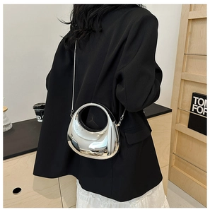 Chic silver crescent bag with mirror finish and metal chain shown in a lifestyle setting