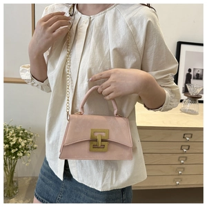Pink vintage chain crossbody bag shown with a white shirt and denim skirt outfit