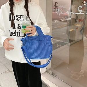 Vue détaillée du velours côtelé bleu Klein et des boucles métalliques du sac