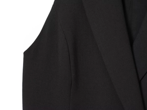 Close-up of premium black woven fabric and precision stitching on the blazer shoulder