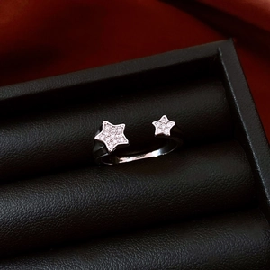 Macro view of silver star rings with sparkling pavé zircons on black leather display