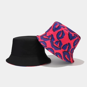 Dettaglio che mostra il design reversibile con lato nero e motivo di labbra blu sul cappello