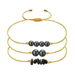 Detailed set of three adjustable braided bracelets with black stones and gold accents