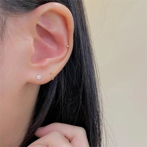 Three-piece set of 925 silver stud earrings and gold hoop shown on a model's ear