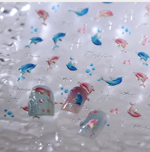 Macro shot of 3D embossed dolphin nail stickers with silver stars and bubbles