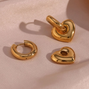 Macro shot of high-polished gold-plated stainless steel heart pendant earring detail