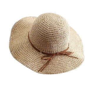 Women's foldable wide brim straw hat with brown bow tie for sun protection