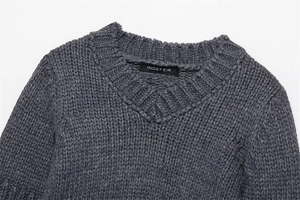 Detail showing dark grey chunky knit texture and V-neckline of the casual sweater
