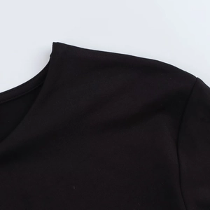 Detail of shoulder stitching and neckline texture on a black long sleeve bodysuit