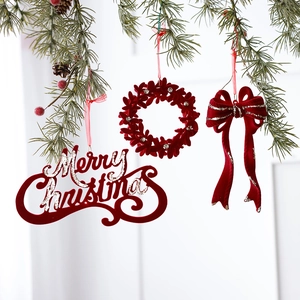 Burgundy velvet Merry Christmas ornaments with bows and wreaths on a pine tree branch