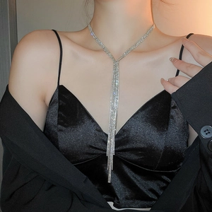 Macro detail of silver layered rhinestone tassel necklace on black evening attire