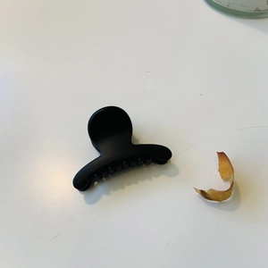 Gros plan d'une pince à cheveux noire mate montrant sa texture lisse et sa prise sûre