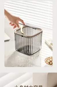 Transparent gray desktop trash bin with vertical stripes and gold press lid