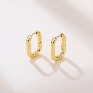 Detailed view of polished 18k gold plated brass U-shaped oval hoop earrings on light base