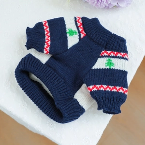 Close-up of navy blue and white striped pet knit sweater with small tree patterns