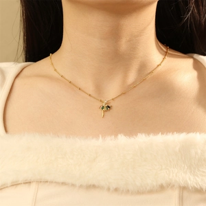 Close-up of a golden ballerina pendant with colorful zircon stones worn by a model