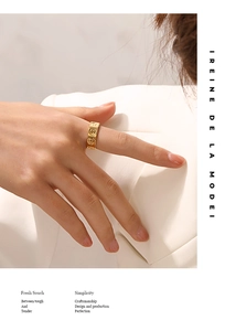 Close-up of model wearing gold-plated smiley face ring with embossed details
