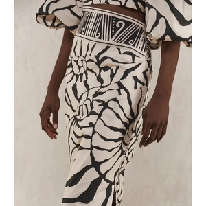 Detailed close-up of high-waisted split midi skirt with abstract black and white print
