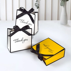 Minimalist white and yellow gift bags with black ribbon bows and Thank You print