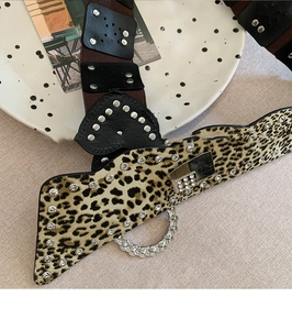 Détail d'une ceinture léopard avec strass, chaînes métalliques et coutures en similicuir