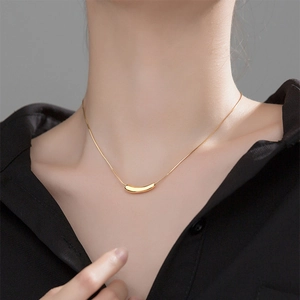 Minimalist gold titanium steel eggplant pendant necklace on model with black shirt