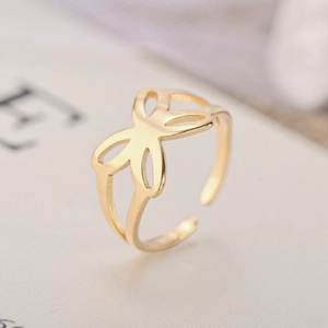 Macro shot of an open golden ring featuring a hollow butterfly design with smooth lines