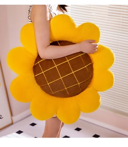 Macro detail of sunflower plush pillow showing soft yellow petals and brown center texture