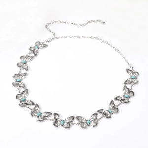 Detailed macro view of butterfly metal waist chain with turquoise-tone stone inlays