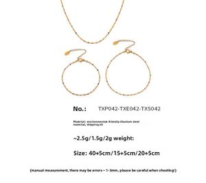 Detail of gold titanium steel jewelry set featuring colorful bead enamel accents