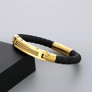 Detailed macro view of woven leather and gold-plated steel strap with a magnetic clasp